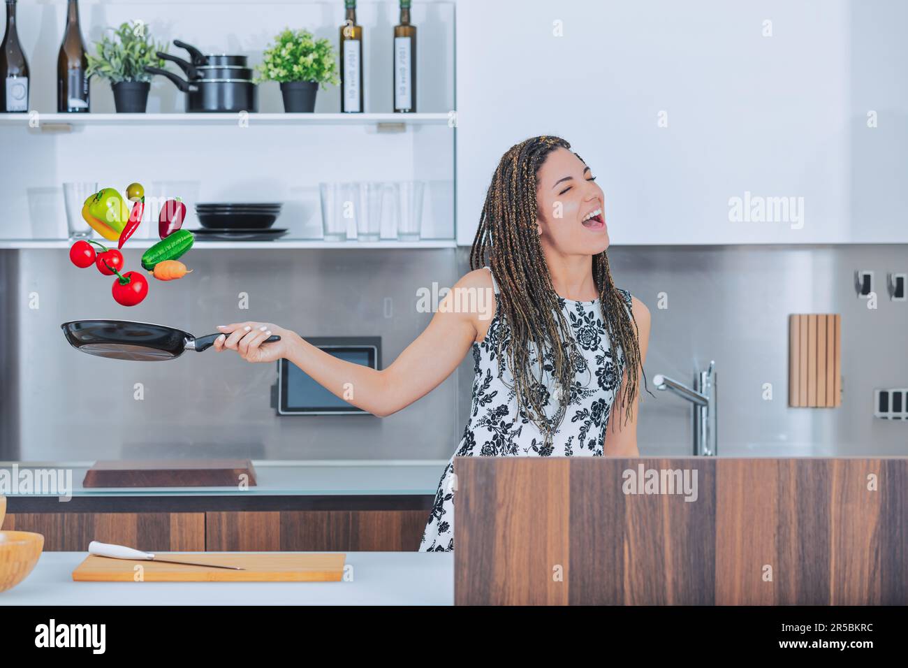 https://c8.alamy.com/comp/2R5BKRC/in-her-spacious-and-modern-kitchen-a-young-woman-joyfully-tosses-vibrant-vegetables-in-the-air-while-singing-she-enjoys-cooking-and-is-a-vegetarian-2R5BKRC.jpg