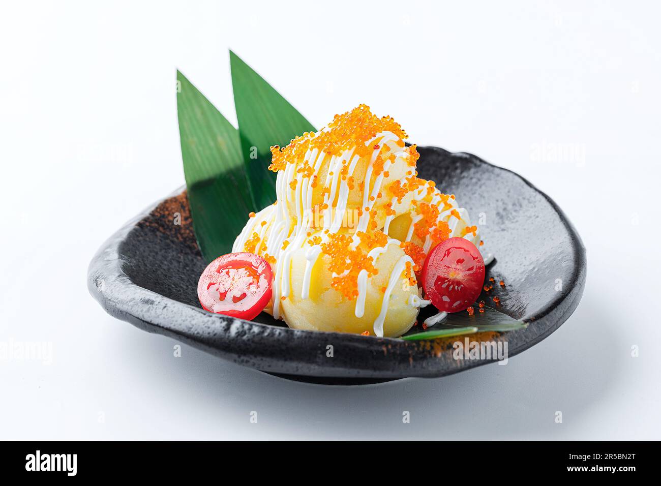 Japanese mashed potato salad drizzled with sweet kewpie mayo and topped with fresh salmon fish egg roe served at a sushi restaurant., Japanese food. Stock Photo