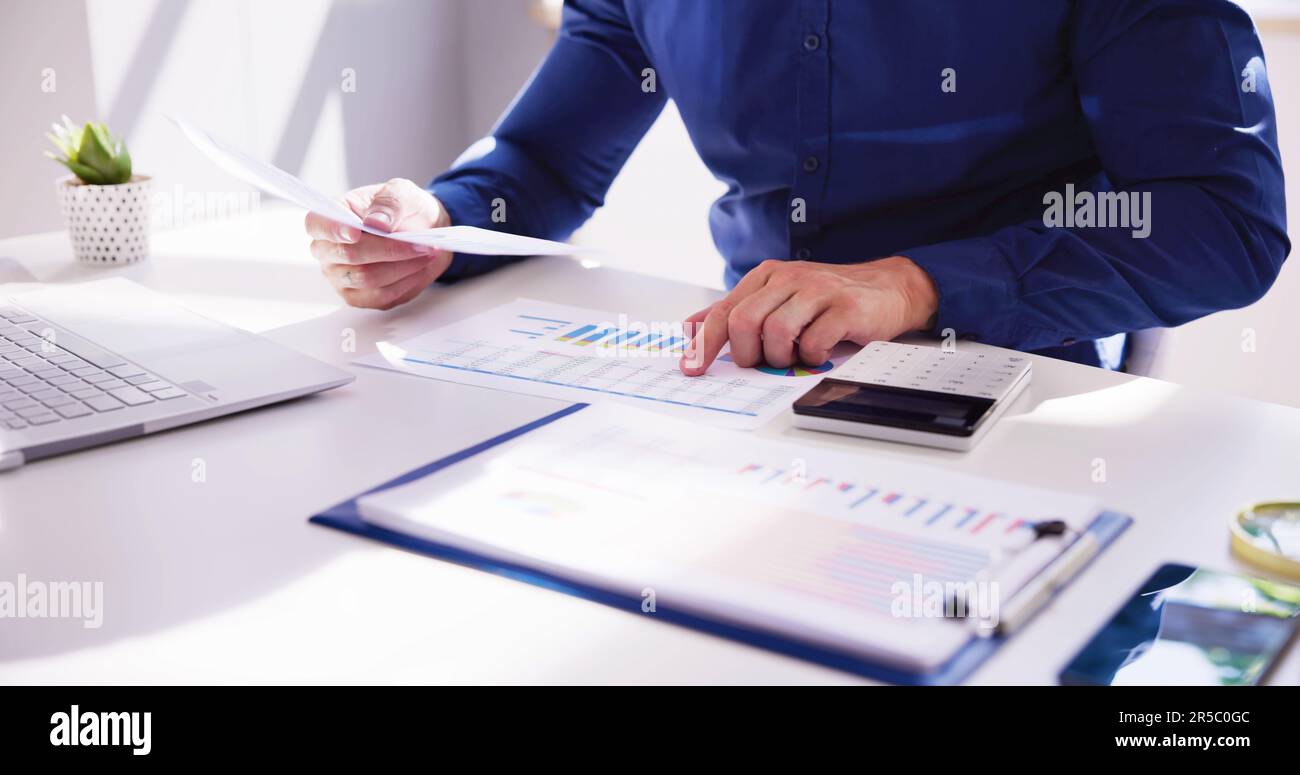 Business Accountant Using Finance Chart Document And Calculator Stock Photo