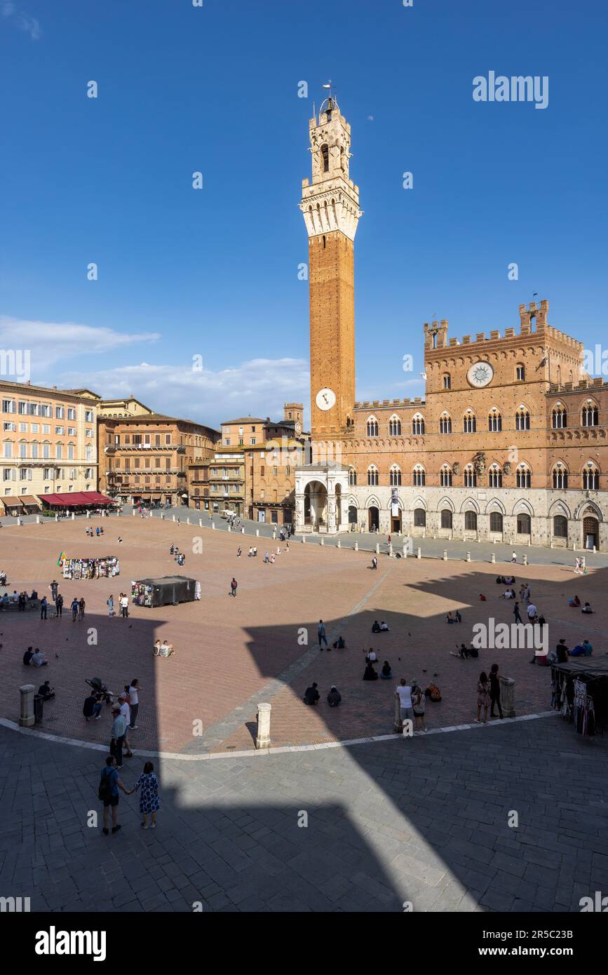 Siena, Siena Province, Tuscany, Italy.  The Palazzo Pubblico with the Torre de Mangia seen across the Piazza del Campo.  The historic centre of Siena Stock Photo