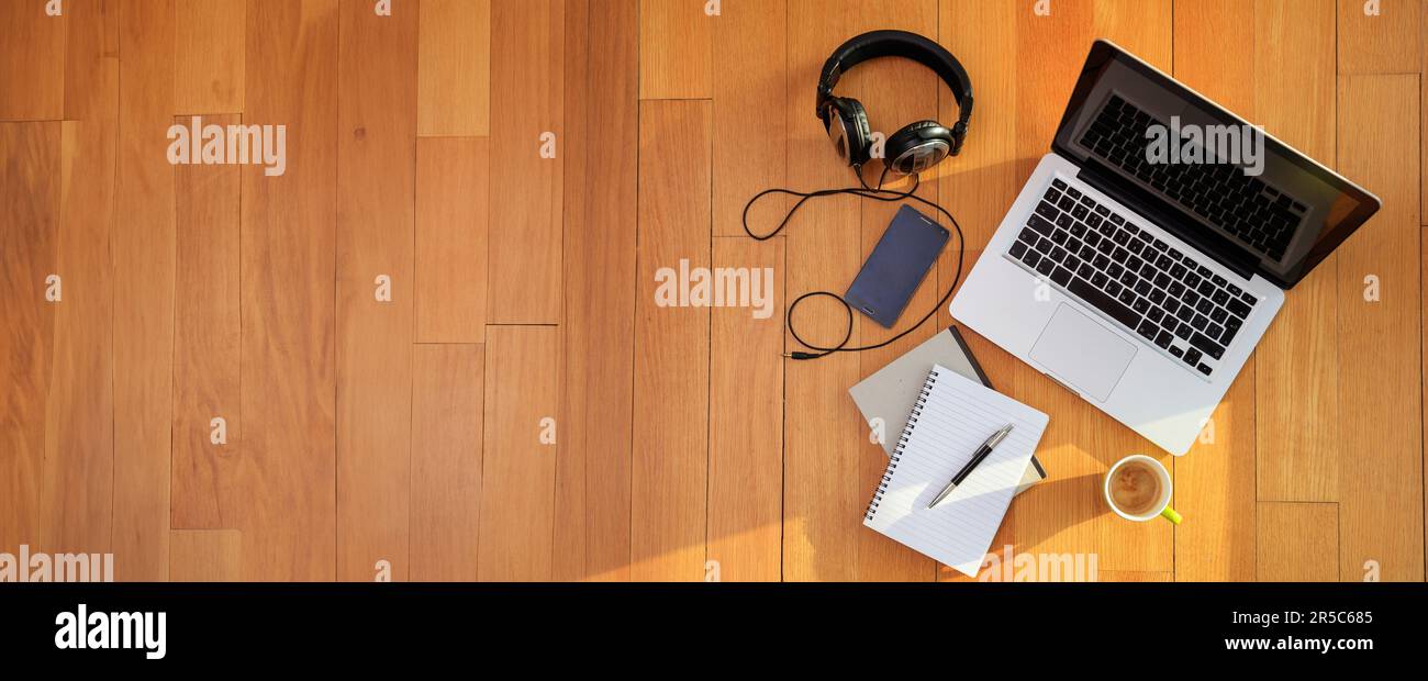 Home office, Work from home. Computer laptop, mobile phone, headphones on the wooden floor, top view Stock Photo