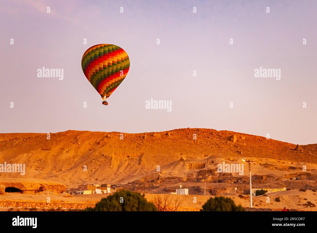 Colorful hot air balloon flying over Valley of The Kings in the morning at Theban Necropolis, Luxor, Upper Egypt Stock Photo