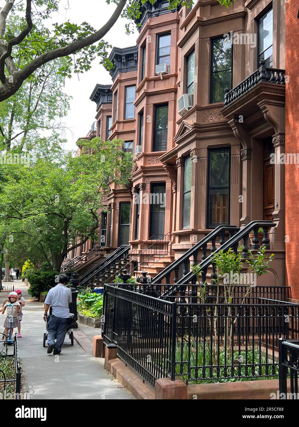 Mailman delivers mail on a residential street in the Park Slope neighborhood of Brooklyn, New York. Stock Photo