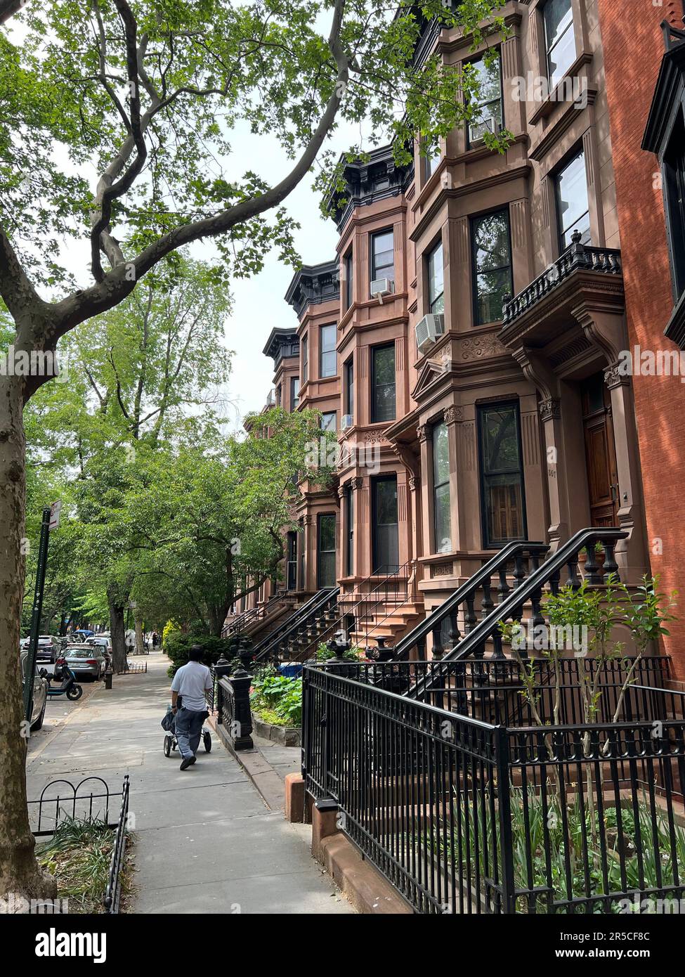 Mailman delivers mail on a residential street in the Park Slope neighborhood of Brooklyn, New York. Stock Photo