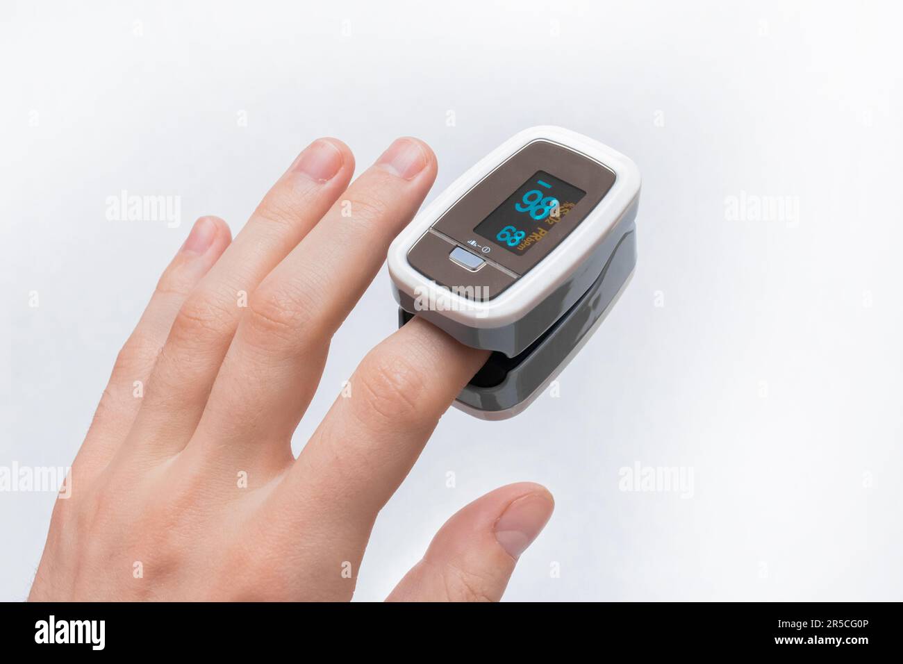 The young man's hand measures the level of oxygen in the blood using a