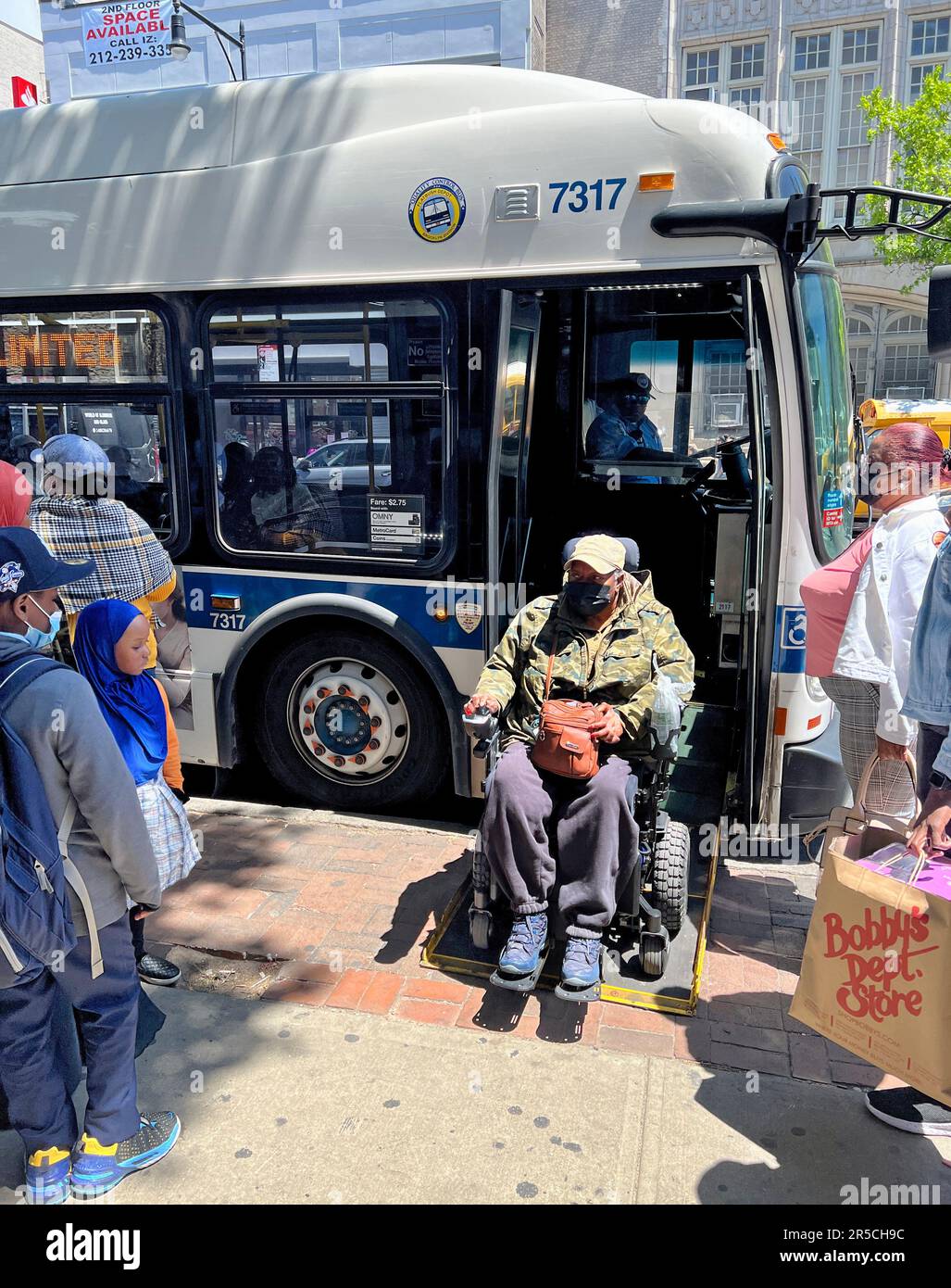 NYC buses are equipped to accommodate disabled people in wheelchairs with retractible ramps to get on and off the bus. Stock Photo