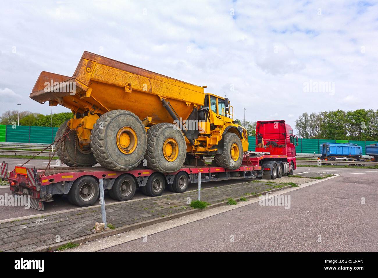 Big truck with a low platform trailer carrying a tipper truck on a