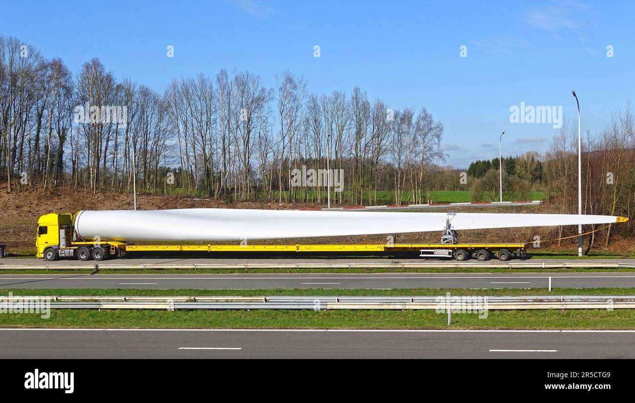 Roadside parking special truck with oversize load transporting a rotor blade for wind power plant turbine Stock Photo