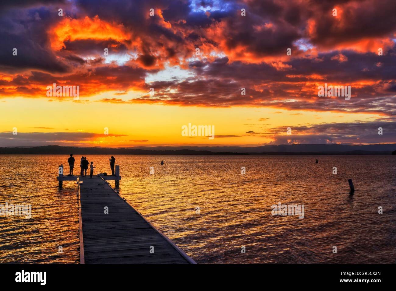 Bright red sunset over waters of Lake Macquarie from Murrays beach boat