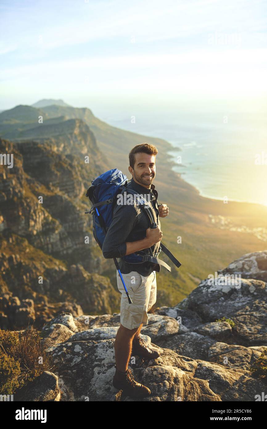 At the tip of the world. a young man hiking up a mountain Stock Photo ...
