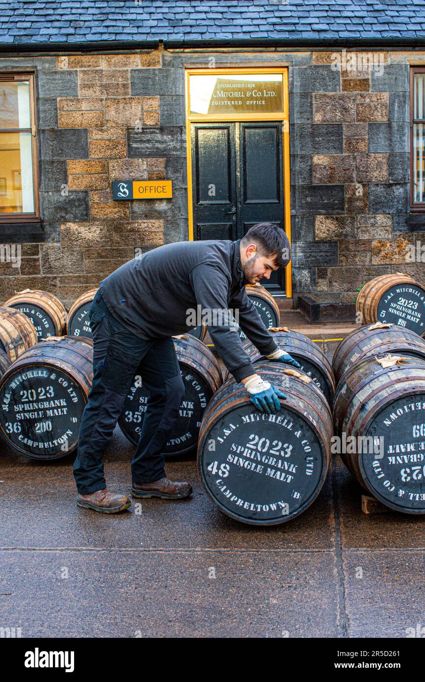 Employee rolling a whisky cask at the Springbank whisky distillery