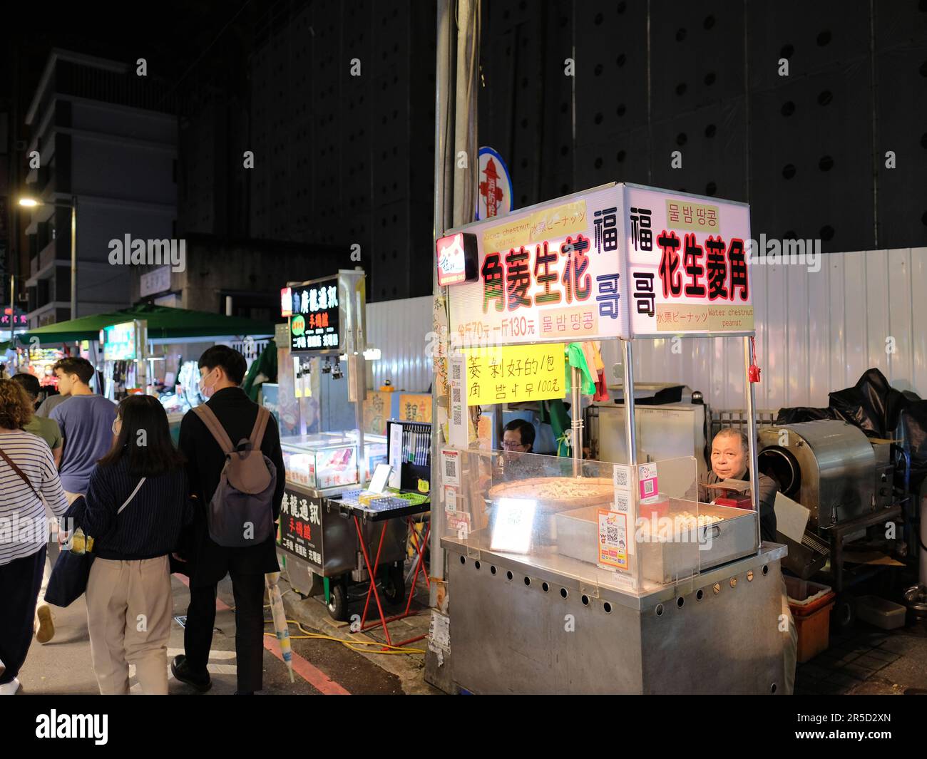 Roasted water chestnut and peanut stand at Huaxi Street Tourist Night Market in Taipei, Taiwan; street food cart; traditional Taiwanese food. Stock Photo