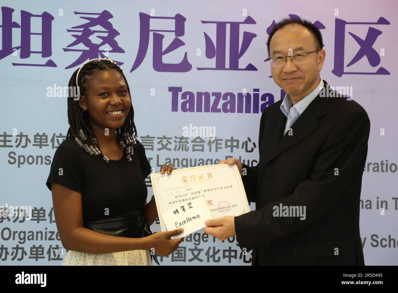 Dar Es Salaam, Tanzania. 1st June, 2023. Esther Michael Masunga (L), a 20-year-old student from Benjamin William Mkapa High School in Dar es Salaam, receives a certificate of the winner of a Chinese language competition in Dar es Salaam, Tanzania, on June 1, 2023. A total of 15 students from 11 secondary schools in Tanzania on Thursday participated in the 16th 'Chinese Bridge' Chinese Proficiency Competition, an annual worldwide Chinese speaking and performance event. Credit: Herman Emmanuel/Xinhua/Alamy Live News Stock Photo