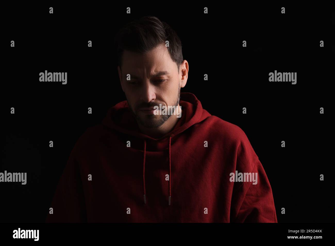Portrait of sad man on black background Stock Photo - Alamy