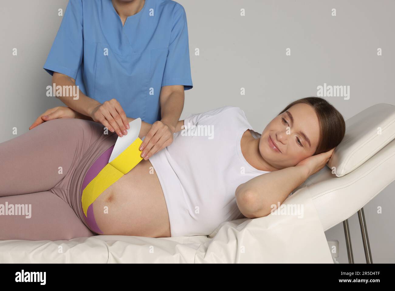 Pregnant woman with kinesio tapes on her belly against white background,  closeup Stock Photo - Alamy