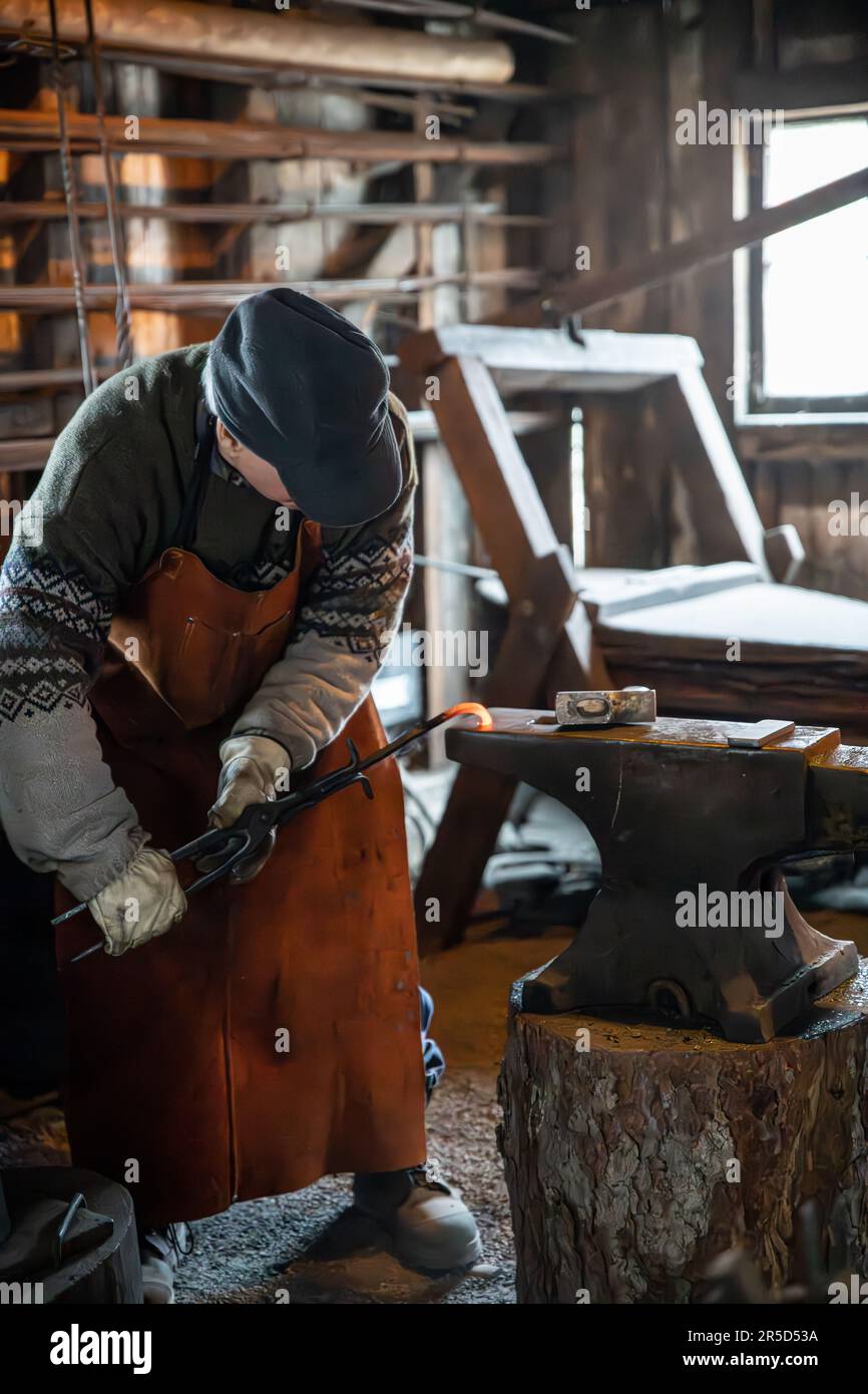 Blacksmith manually forgeing metal object Stock Photo - Alamy
