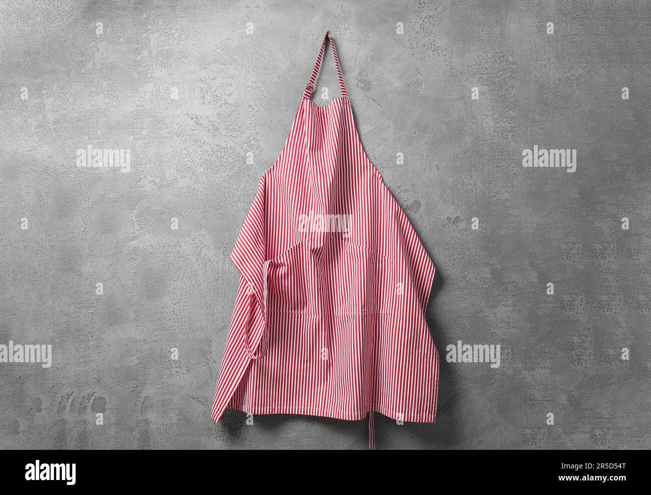 Clean red striped apron on grey tiled wall Stock Photo - Alamy