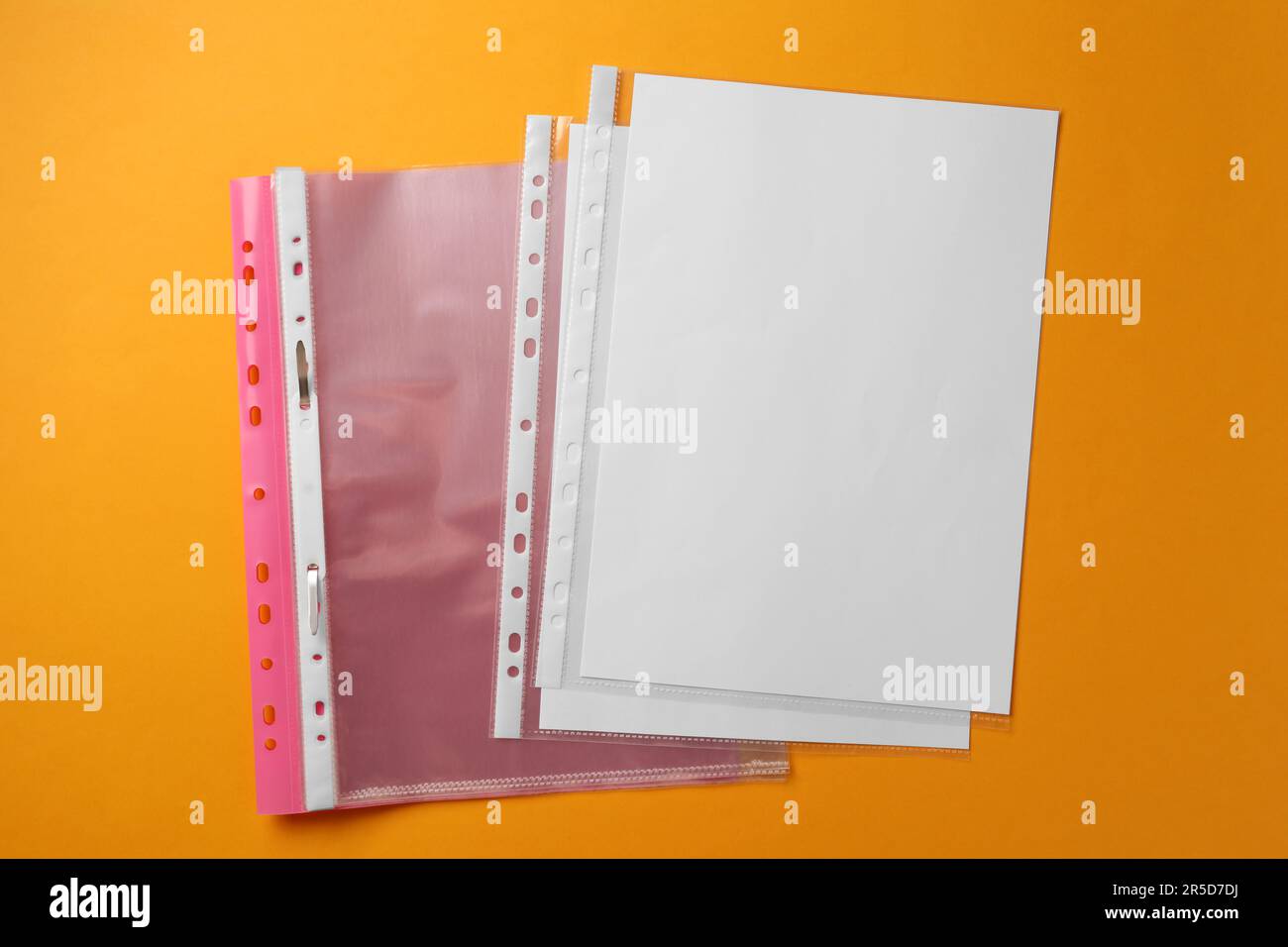 File folder with punched pockets on orange background, flat lay Stock Photo