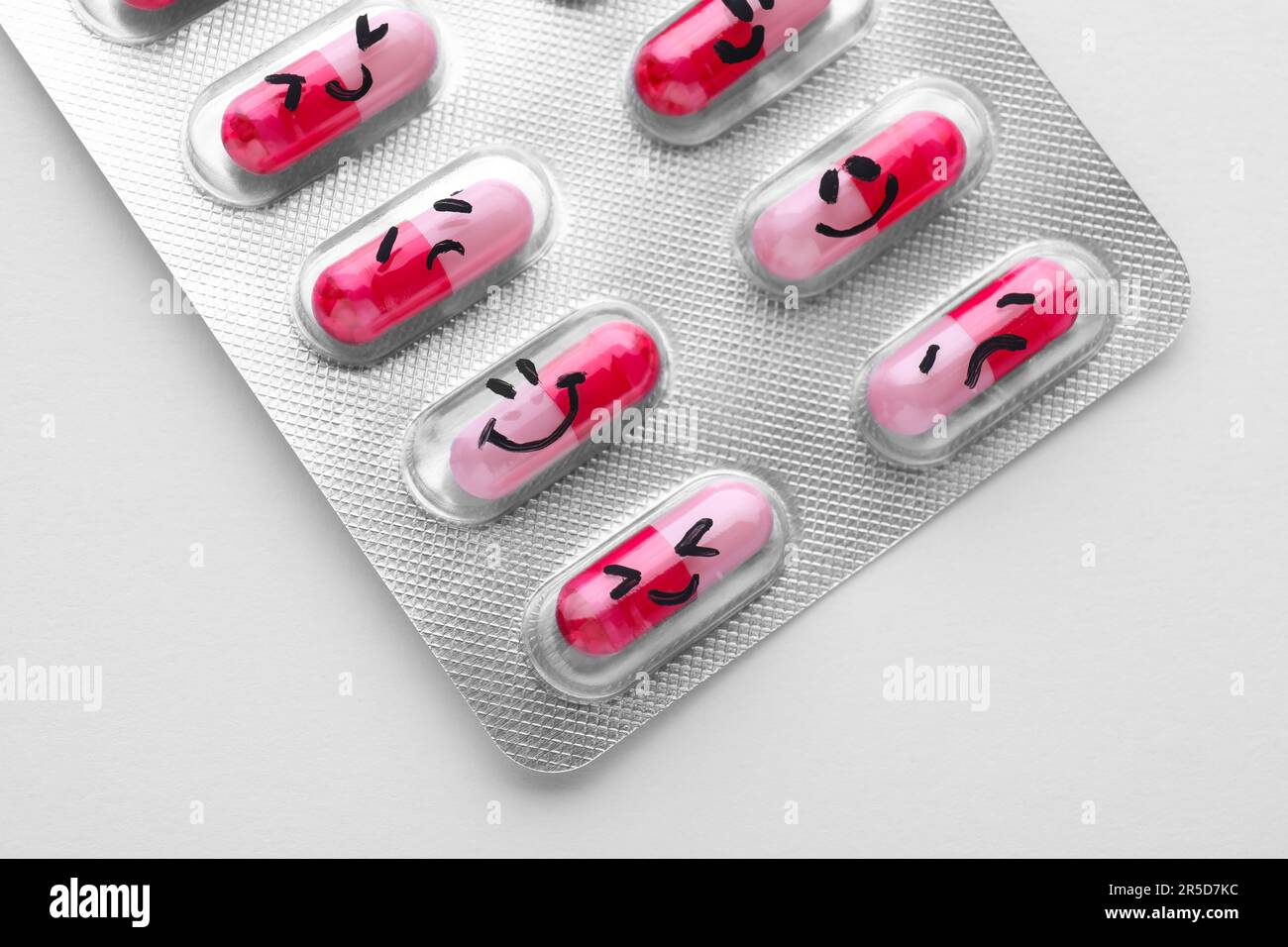 Blister of antidepressant pills with emotional faces on white ...