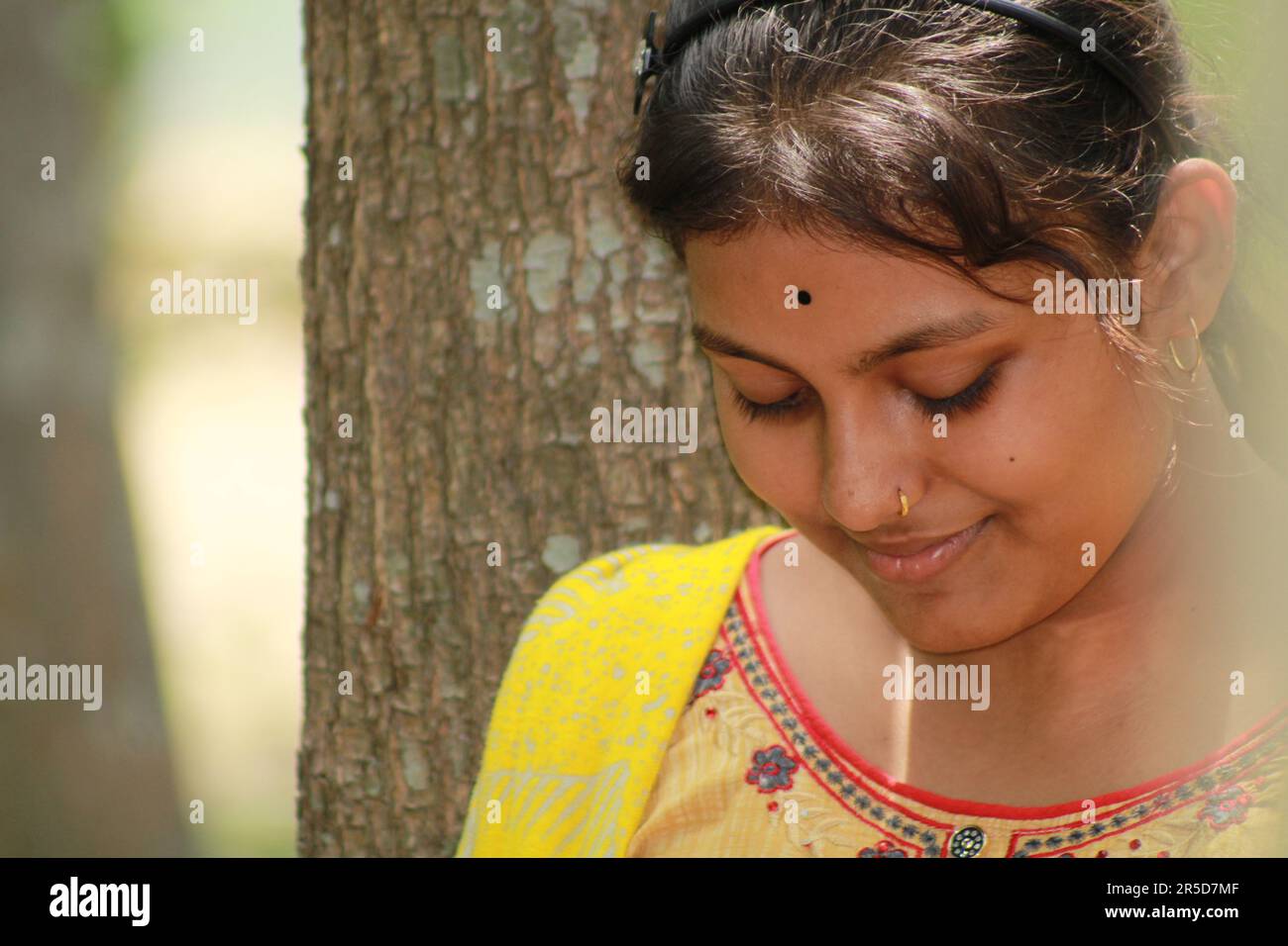 Close-up portrait of a Indian teenage girl looking at camera over nature background. Stock Photo