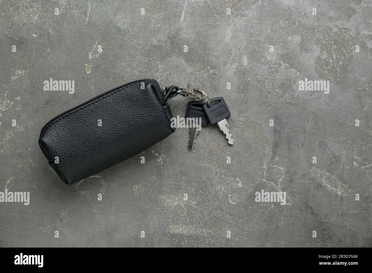 Leather case with keys on grey textured table, top view. Space for text Stock Photo