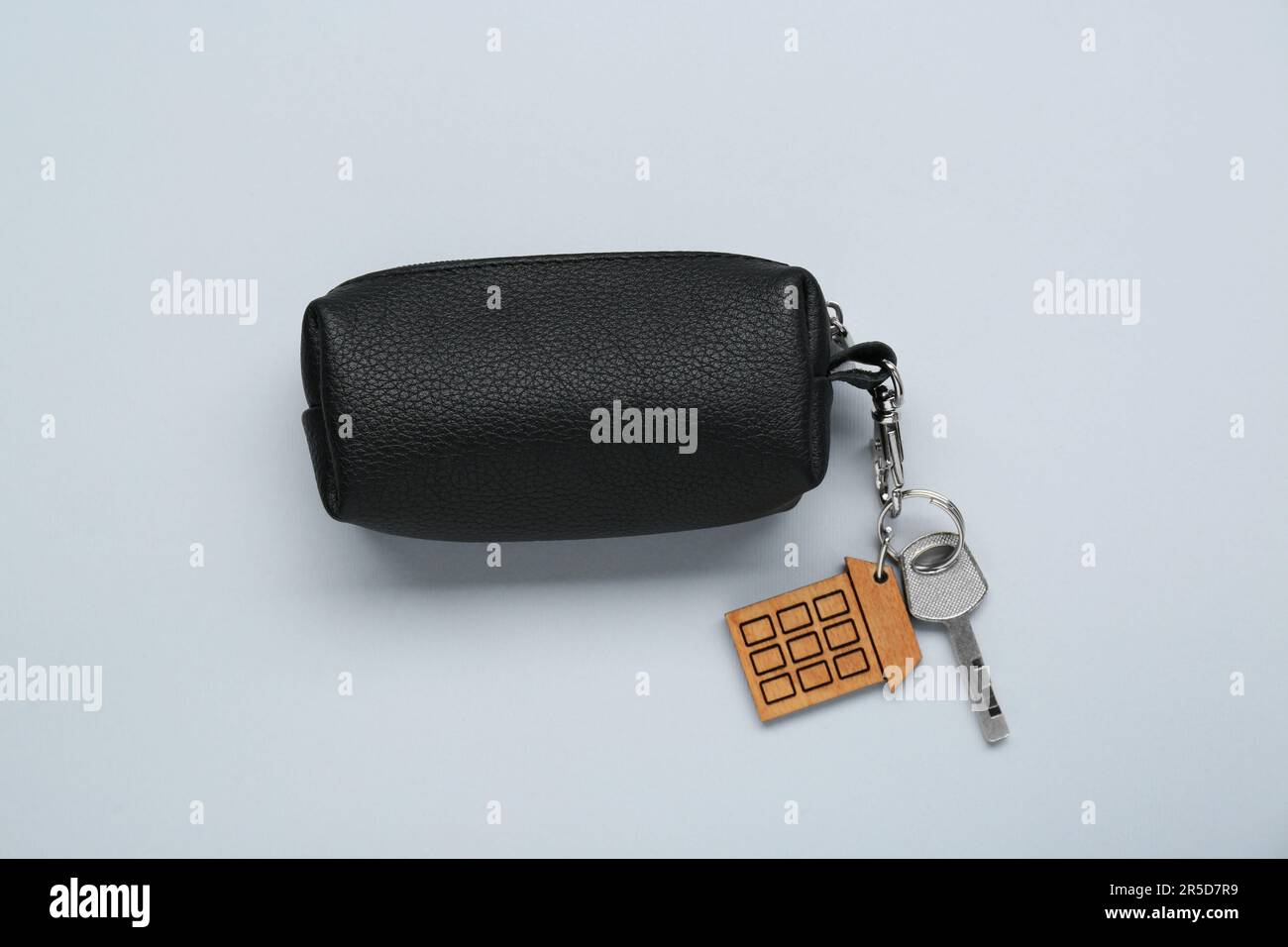 Leather case with key on light grey background, top view Stock Photo