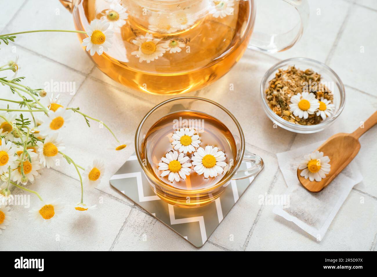 Cup of hot chamomile tea on white tile background Stock Photo - Alamy