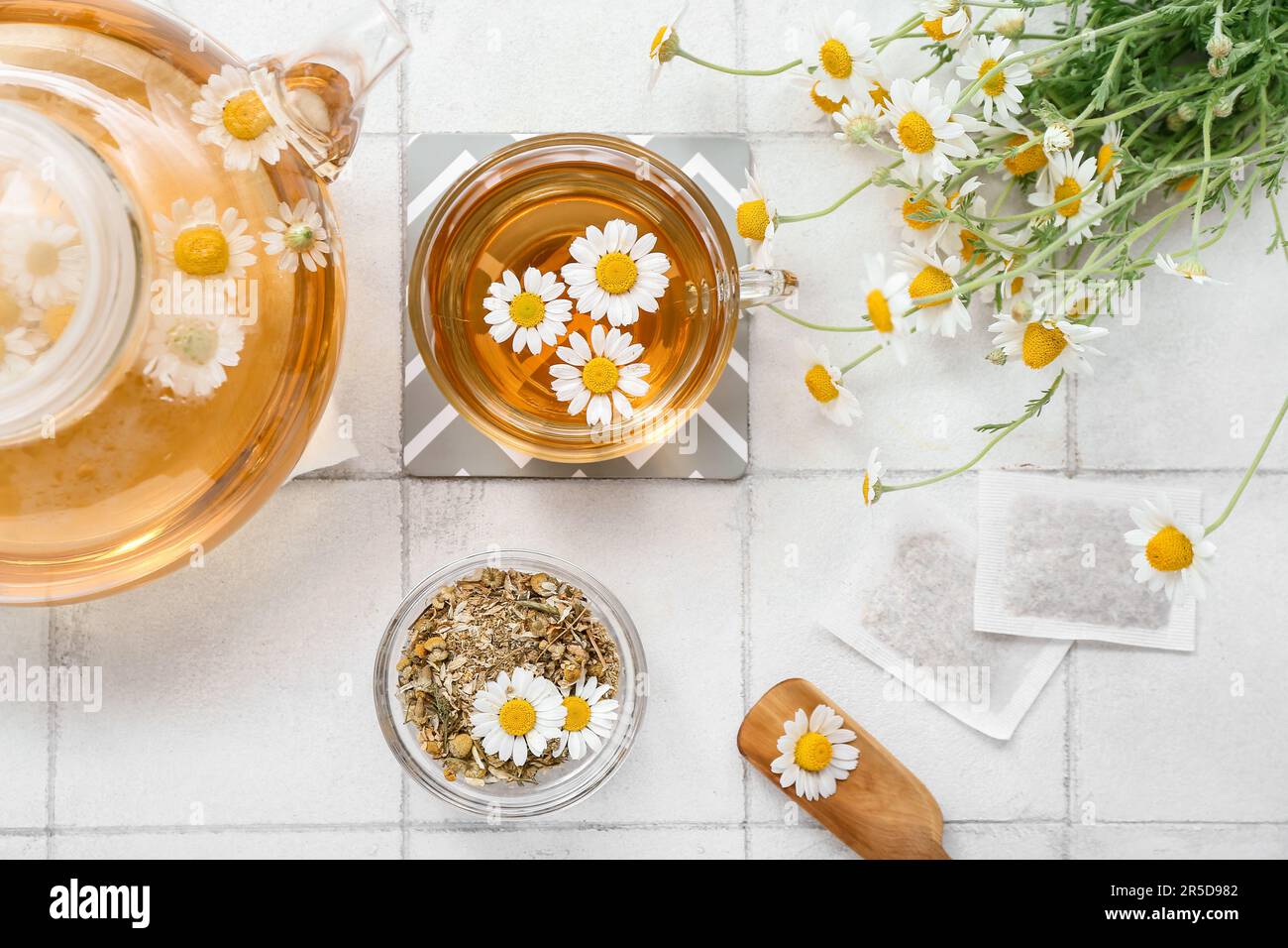 Cup of hot chamomile tea on white tile background Stock Photo - Alamy
