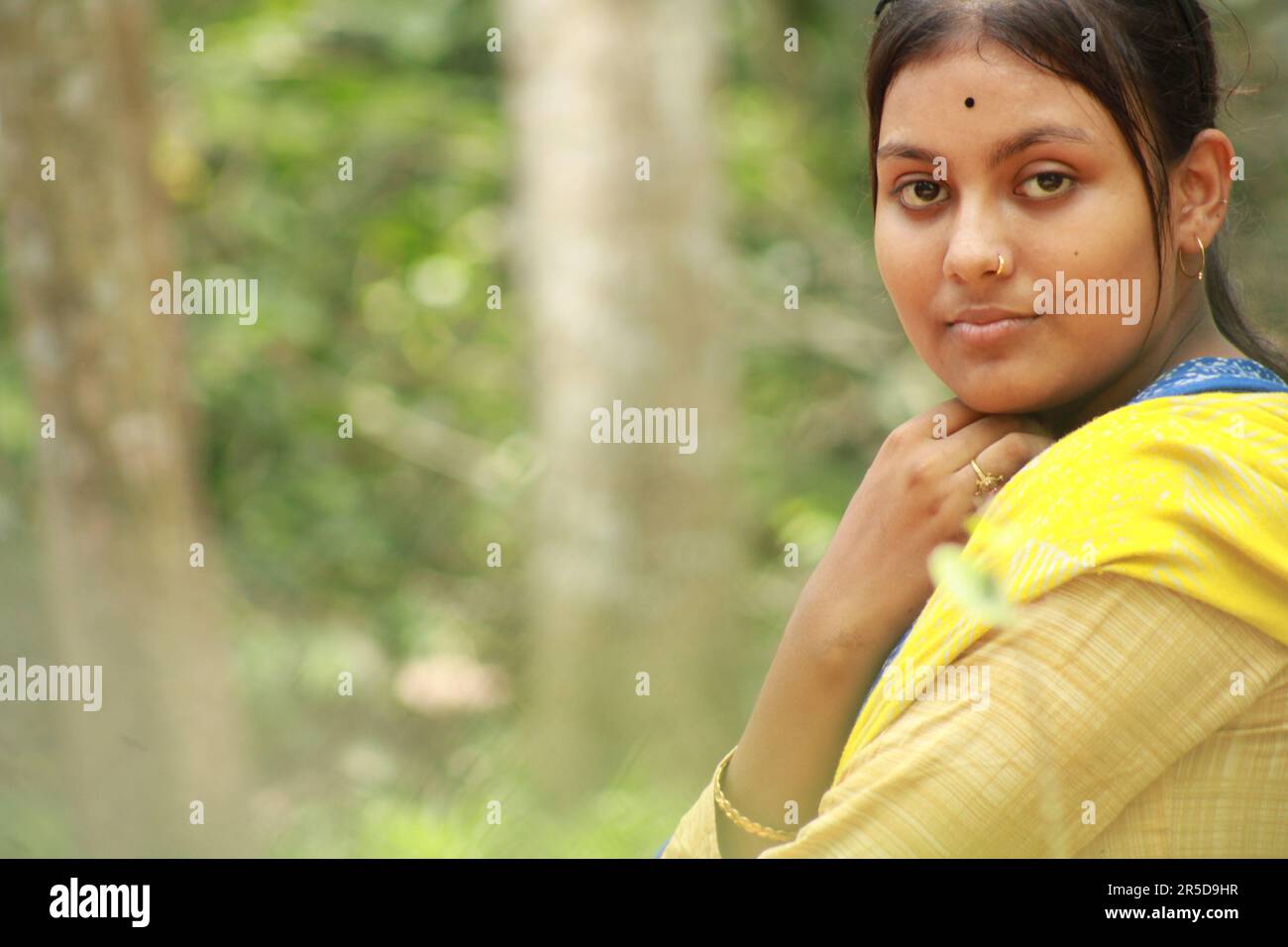 Close-up portrait of a Indian teenage girl looking at camera over nature background. Stock Photo