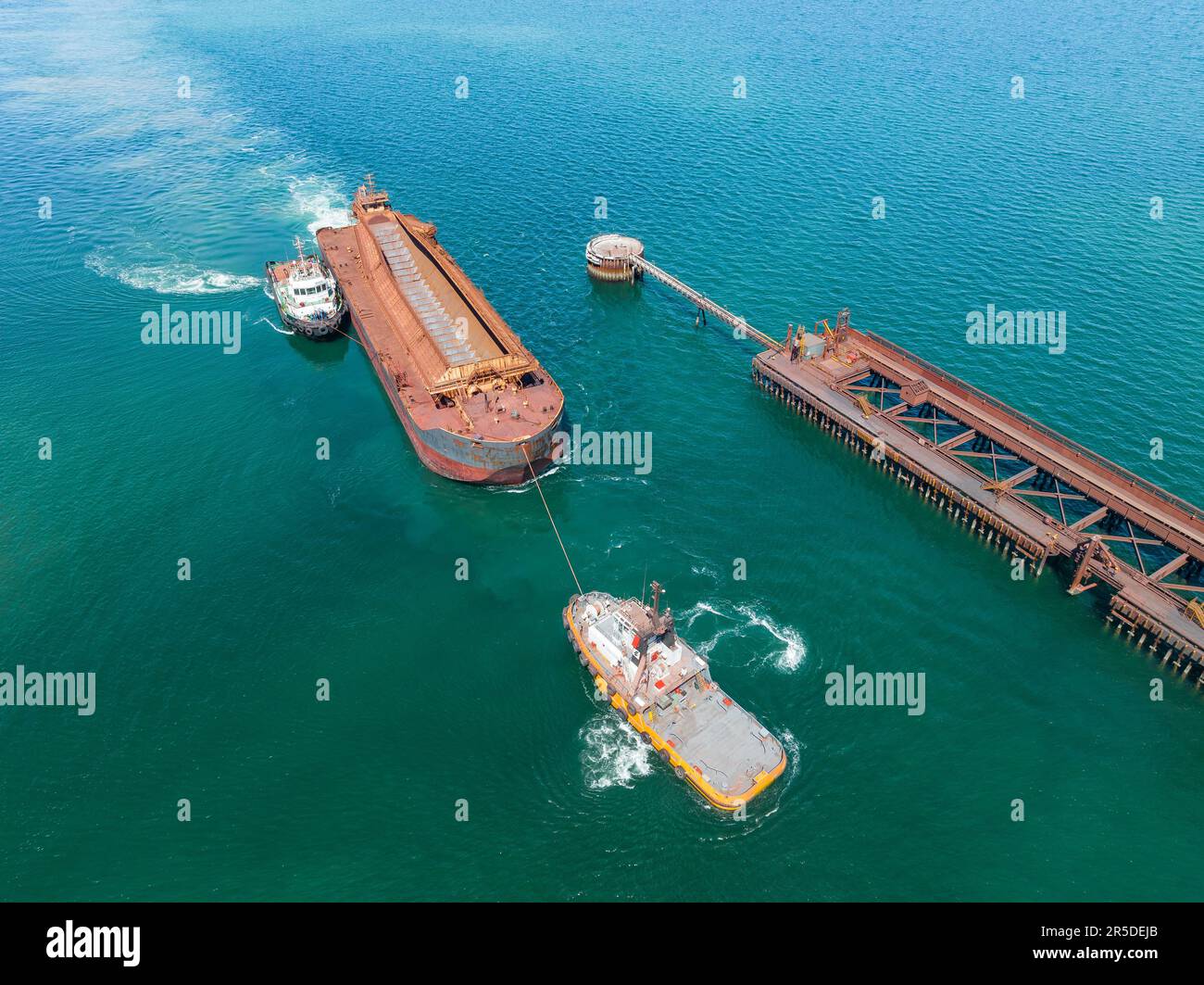 Aerial View Of Tugboats Moving A Large Boat Towards A Wharf At Whyalla aerial-view-of-tugboats-moving-a-large-boat-towards-a-wharf-at-whyalla