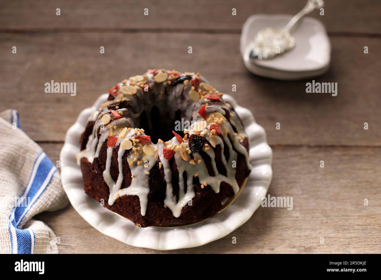 Chocolate Christmas Bundt Fruit Cake with Lemon Frosting, Fruity and Chopped Almonds Toping Stock Photo