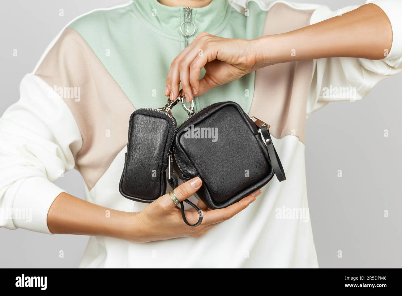 Female Hands Holding Small Black Leather Accessories for Storing Keys, Electronic Cigarette or Earphones Stock Photo