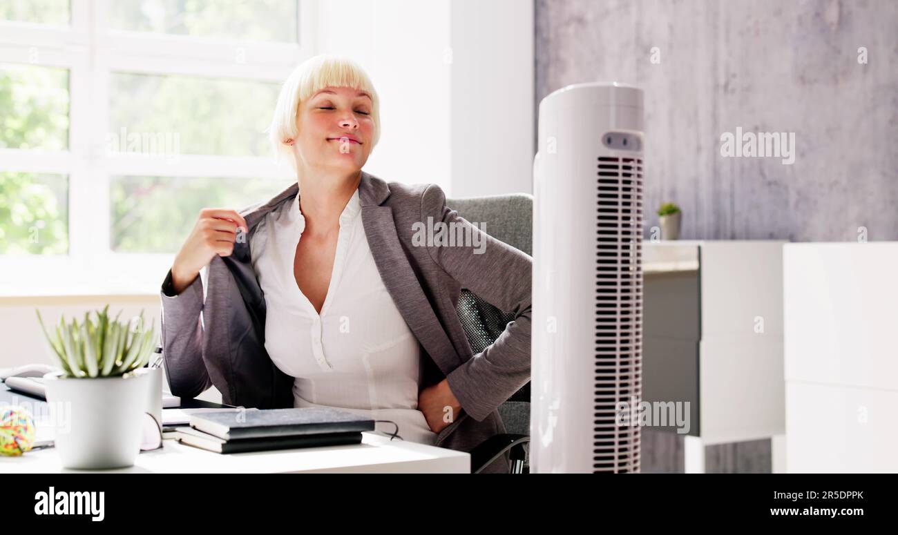 Electric Ventilator Fan In Hot Office Blowing Cool Breeze Stock Photo