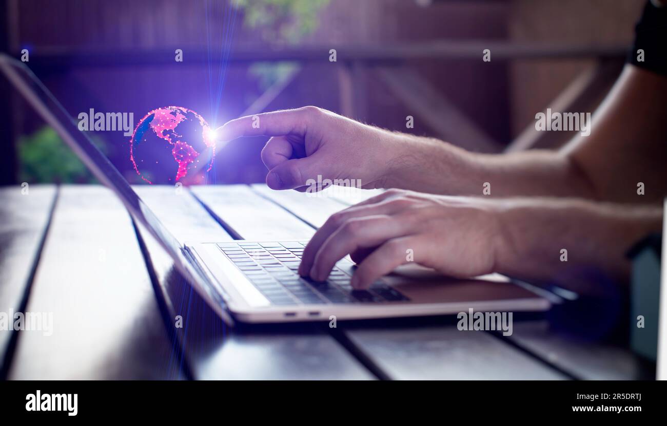 Man using laptop with digital sphere hologram on blurry background. Technology Stock Photo