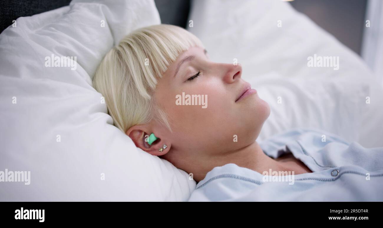 Woman Sleeping With Earplugs In Her Ears In Bed Stock Photo Alamy