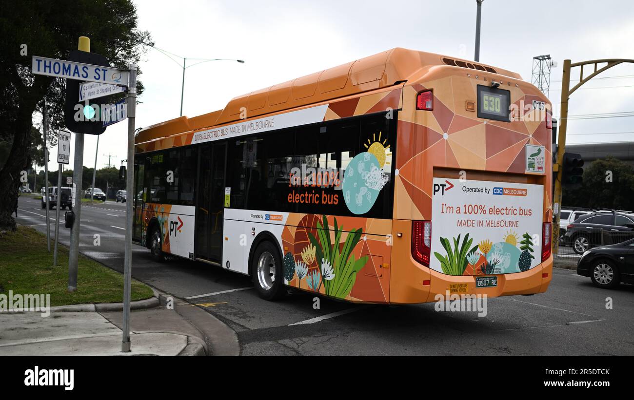 Rear view of an orange and white Volgren Volvo BZL electric bus, operated by CDC Melbourne, traveling along North Rd Stock Photo