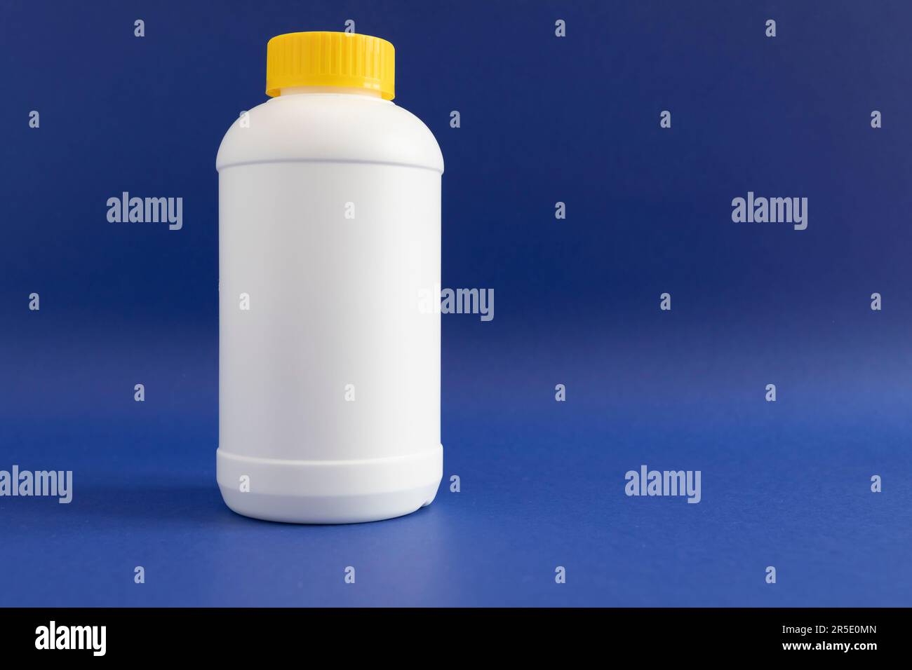 Pipe Unclogging Granules In Yellow Cap, White Plastic Bottle On Blue
