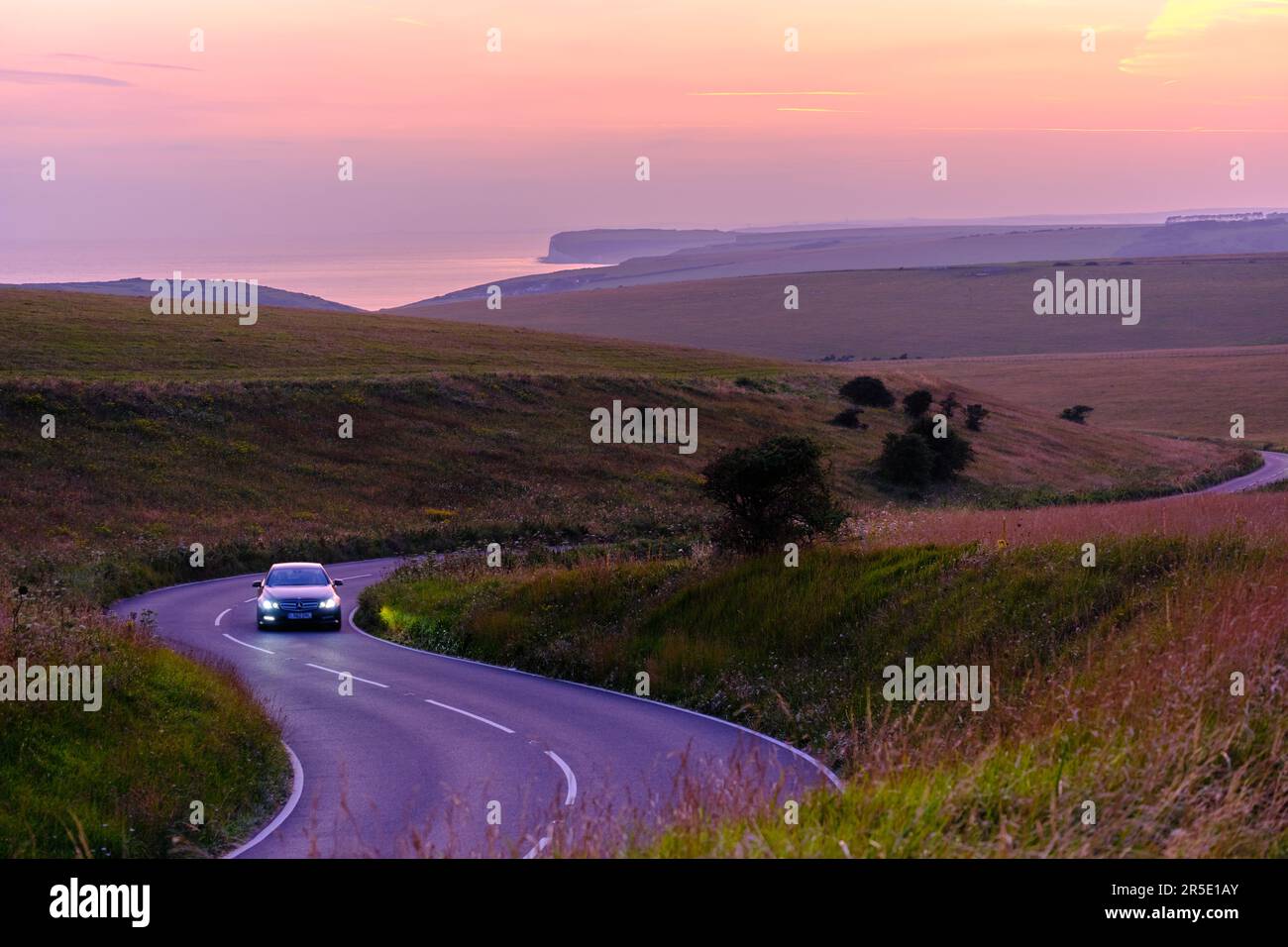 A car travelling along a winding road in East Sussex with Belle Tout