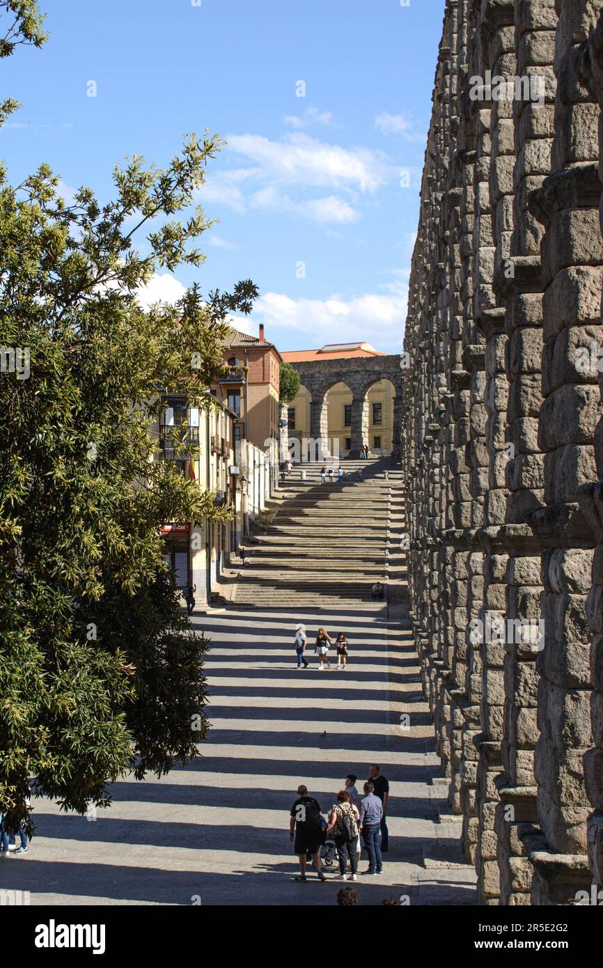The Roman Aqueduct of Segovia (Acueducto de Segovia) in Spain. Path and steps alongside the section of the acqueduct over the Plaza del Azogue. Stock Photo