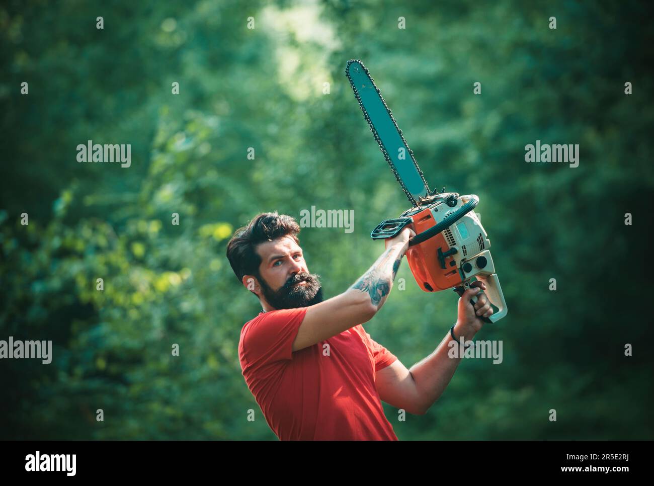 Woodworkers lumberjack. Lumberjack on serious face carries chainsaw