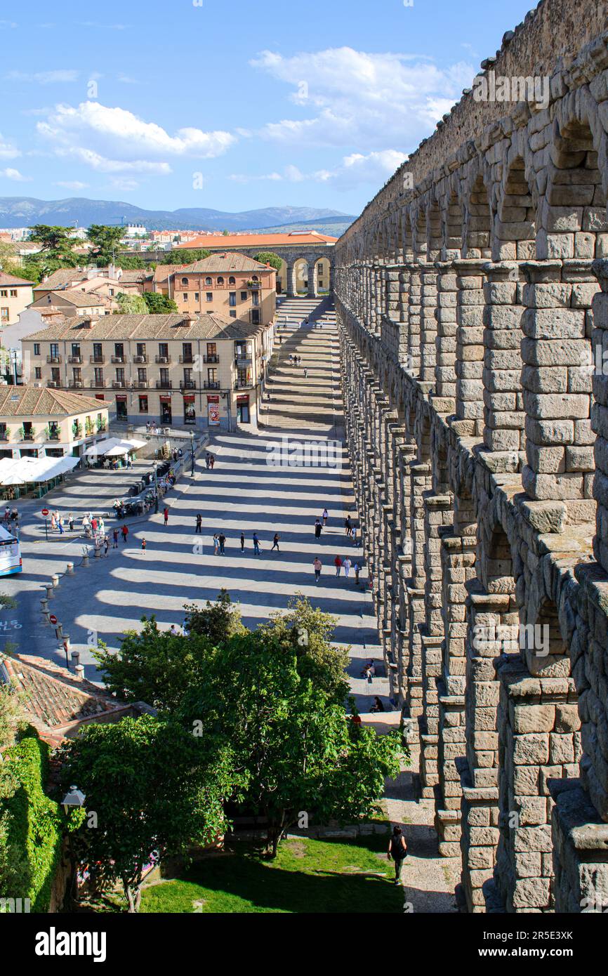 The Roman Aqueduct of Segovia (Acueducto de Segovia) in Spain. Path and steps alongside the section of the aqueduct over the Plaza del Azogue. Stock Photo