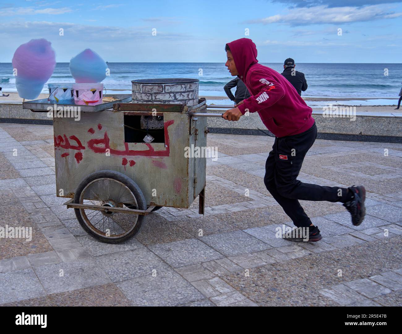 Sousse, Tunisia, January 22, 2023: A Tunisian cotton candy seller walks his handcart along the beach promenade in search of customers Stock Photo
