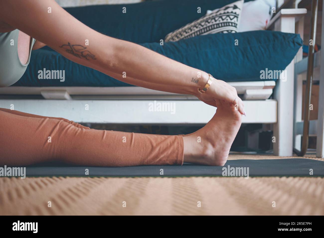 Closeup of Healthy Young Woman Touching Feet while Doing