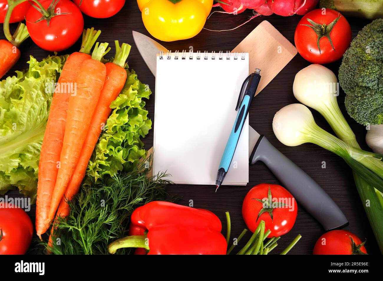 recipe book with vegetables on kitchen table Stock Photo