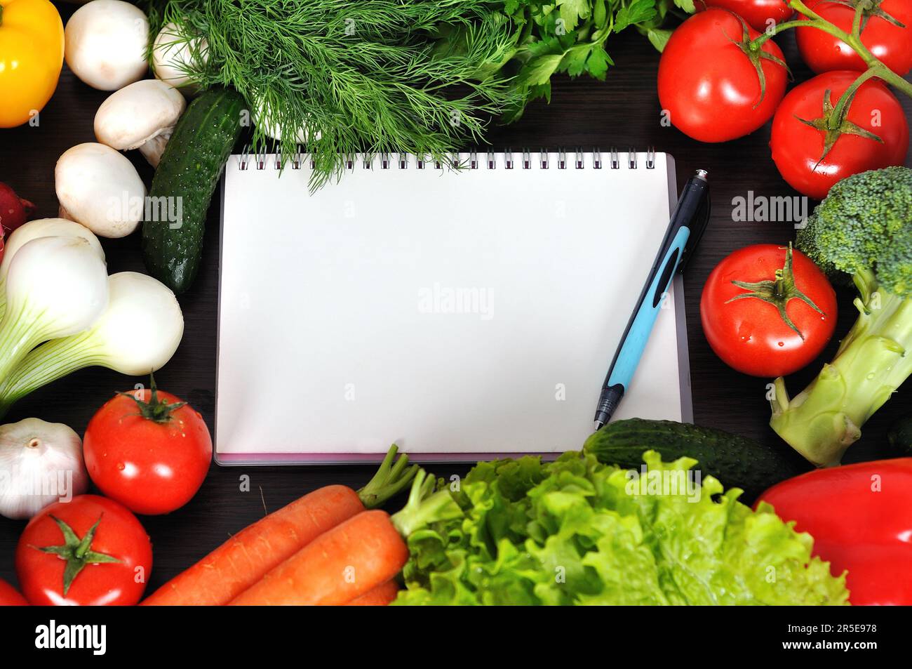 recipe book with vegetables and herbs on wooden background Stock Photo