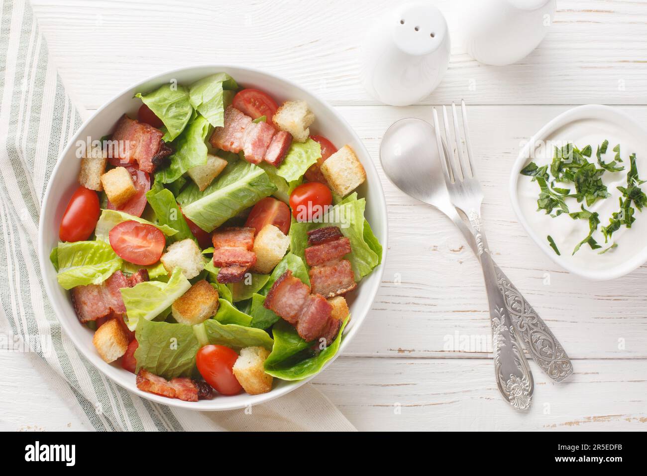 Healthy Organic BLT Bacon Salad with Lettuce and Tomato closeup on the plate on the table. Horizontal top view from above Stock Photo