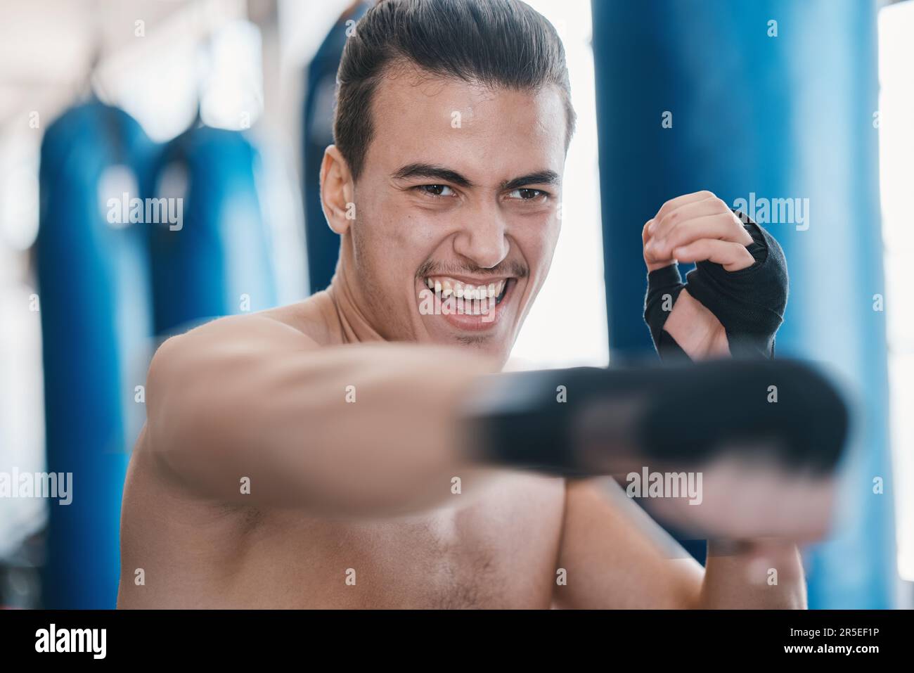 Sports, boxing and man punch in gym for training, workout and exercise