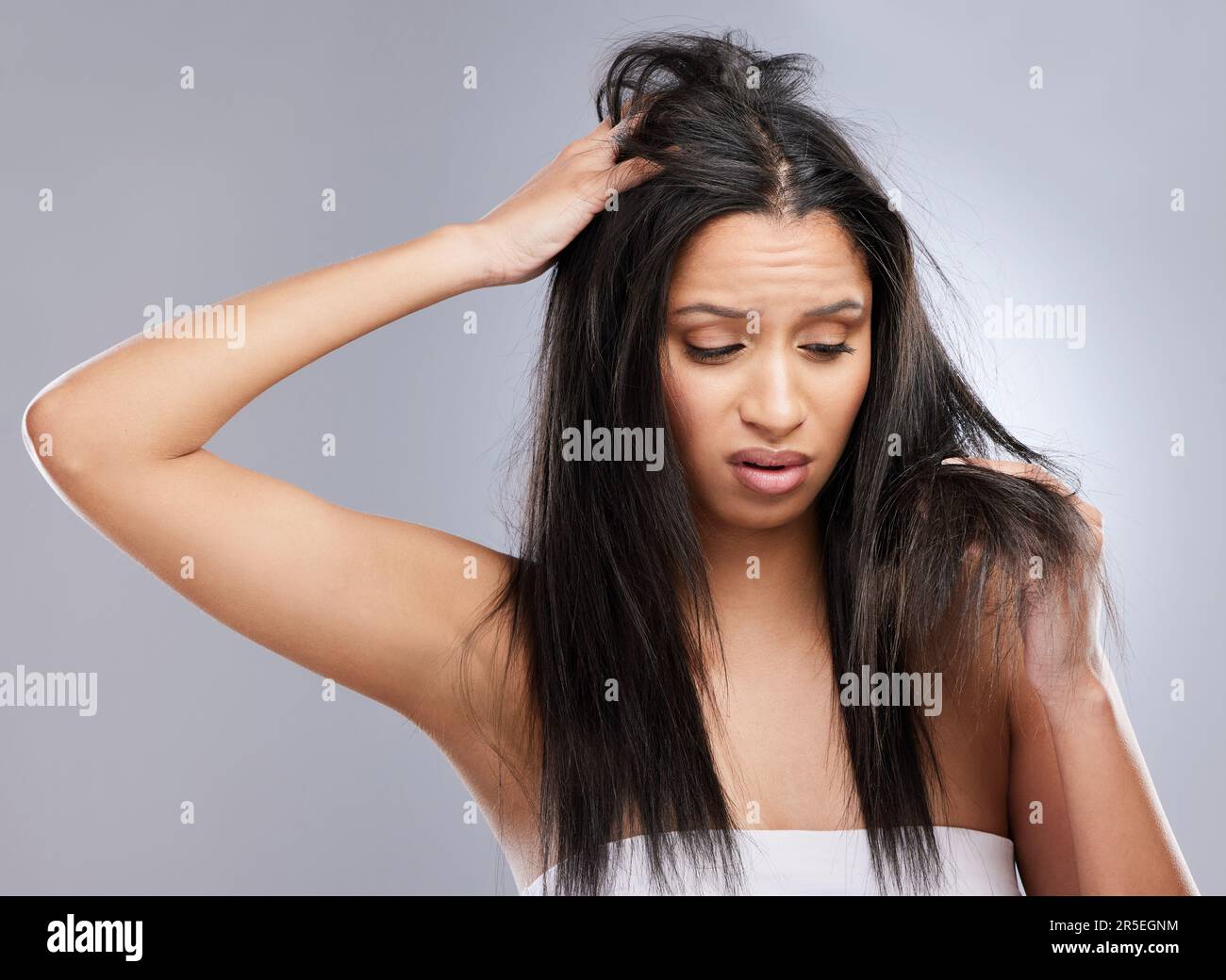 Hair, damage loss and woman in studio with worry for split ends, haircare crisis and weak strand. Beauty, hairdresser and face of female person with Stock Photo