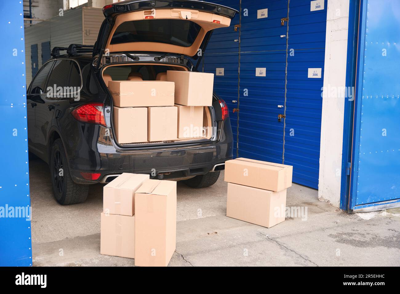 Car with cardboard boxes in the trunk into a warehouse with self