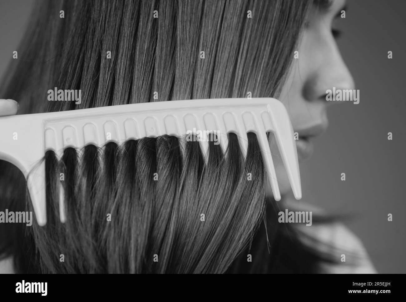 Close up hair lady combing hair with hairbrush comb, isolated. Long healthy